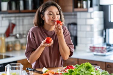 Mutfak masasında yemek hazırlayan gülümseyen kadın. Mutfakta salata yapan kadın.. 