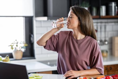 Mutfakta su içen kadın. 