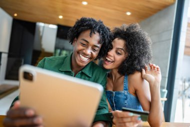 Dijital tablet kullanan genç bir çiftin portresi internetten sipariş veriyor.