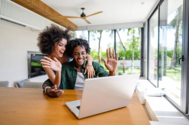 Genç mutlu Afrikalı çift evlerinde dizüstü bilgisayar kullanıyor. Yaşam tarzı, iletişim ve teknoloji kavramı.