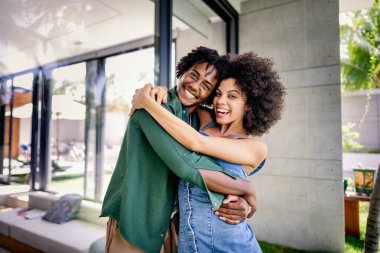 Mutlu çok ırklı çift sarılıyor ve gülümsüyor. 