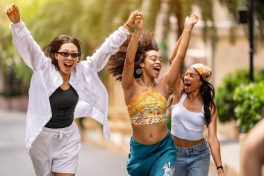 Bir grup mutlu genç arkadaş bir sokakta birlikte yürüyorlar..