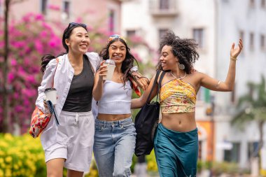 Bir grup mutlu genç arkadaş bir sokakta birlikte yürüyorlar..