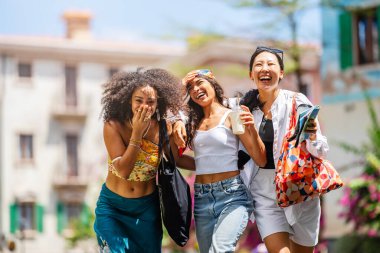 Bir grup mutlu genç arkadaş bir sokakta birlikte yürüyorlar..