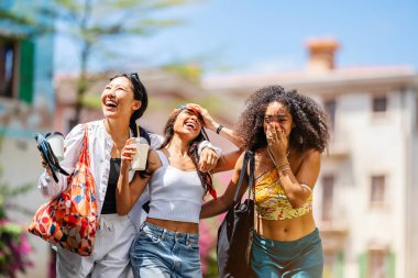 Bir grup mutlu genç arkadaş bir sokakta birlikte yürüyorlar..