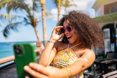 Plajda cep telefonuyla selfie çeken bir kadın.. 