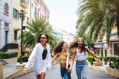 Mutlu genç kadınlar yürüyor ve gülüyor. 