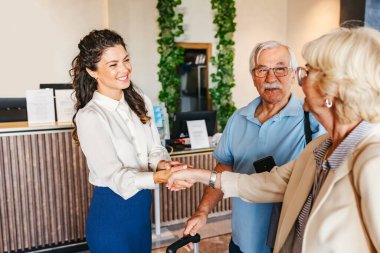 Otel resepsiyonundaki yaşlı çiftle mutlu bir yönetim.