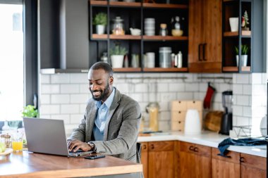 Genç Afrikalı Amerikalı adam mutfaktan çalışıyor.