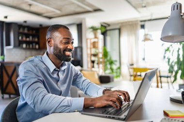 Genç Afrikalı adam evde çalışıyor. 