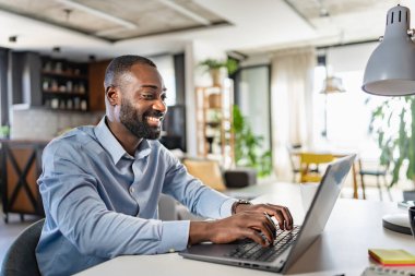 Genç Afrikalı adam evde çalışıyor. 