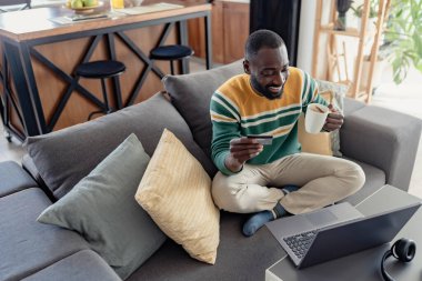 İnternetten sipariş veren mutlu Afro-Amerikan adam. 