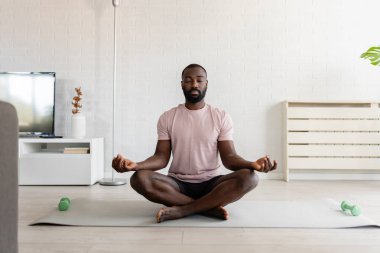 Adam evde Lotus pozisyonunda meditasyon yapıyor. 