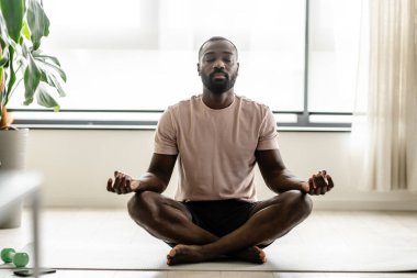 Afro-Amerikan adam evde meditasyon yapıyor..