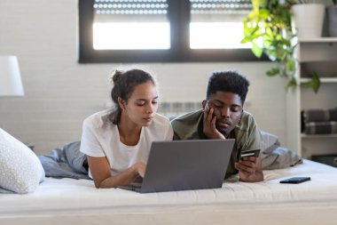 Çift evde dizüstü bilgisayar ve kredi kartı kullanıyor. çevrimiçi alışveriş 