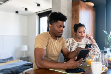 Çift kahvaltıda telefonla konuşuyor.