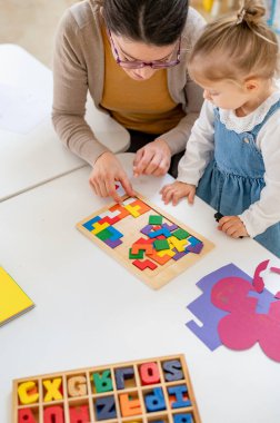 Mutlu öğretmen ve kız oyuncaklarla oynuyor. 