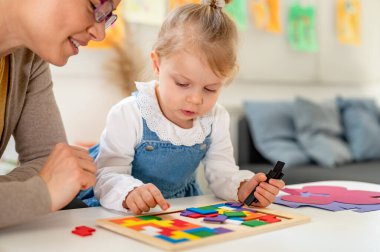 Çocuk ve öğretmen tahta küplerle oynuyorlar. eğitim ve yaratıcılık