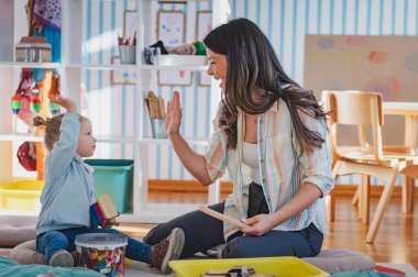 Anne ve kızı yüksek beş veren 