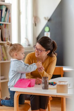 Mutlu öğretmen ve kız oyuncaklarla oynuyor. 
