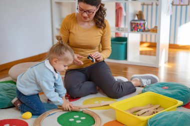 Anaokulunda oynayan mutlu öğretmen ve kız çocuk..