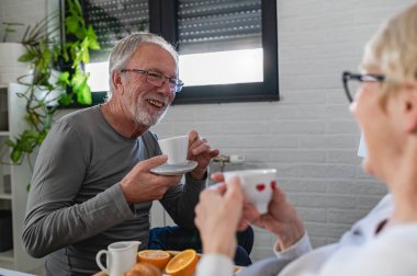 Mutlu olgun çift evde kahve içiyor. 