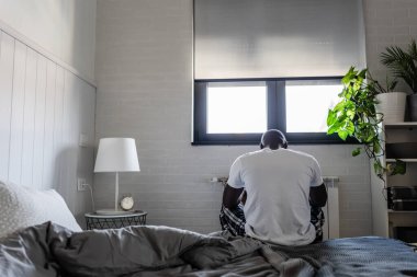 Genç Afrikalı Amerikalı adam sabahın erken saatlerinde yatak odasında. 