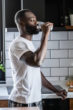 Afro-Amerikan adam camdan su içiyor. 