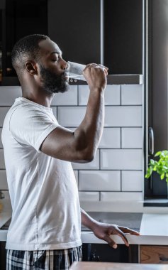 Afro-Amerikan adam camdan su içiyor. 