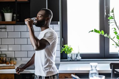 Afro-Amerikan adam camdan su içiyor. 