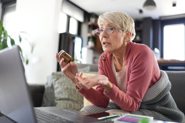 Mutfakta dizüstü bilgisayarı olan son sınıf öğrencisi bir kadın doktorla çevrimiçi görüşme yapıyor. 
