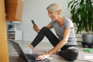 İnternette egzersiz yapan olgun, son sınıf öğrencisi bir kadın. 