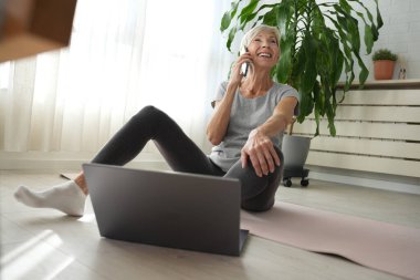 İnternette egzersiz yapan olgun, son sınıf öğrencisi bir kadın. 