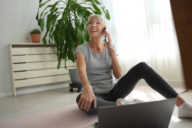İnternette egzersiz yapan olgun, son sınıf öğrencisi bir kadın. 
