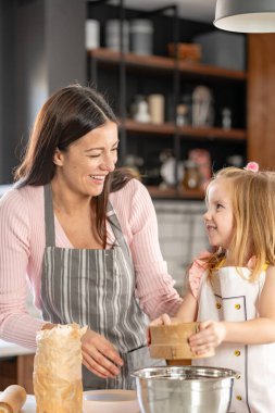 Mutlu anne ve kız mutfakta hamur işi yapmaya hazırlanıyor. 