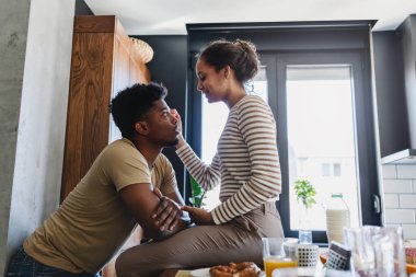 Çift modern mutfakta kahvaltıdan zevk alıyor.