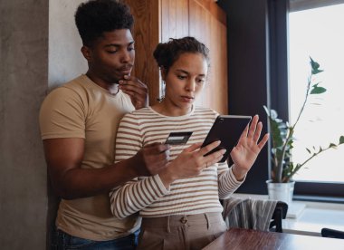 Evde tablet ve kredi kartı kullanan çift