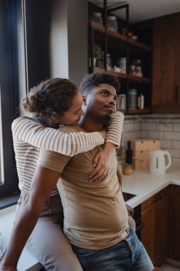 Modern mutfak ortamında sarılan kadın.