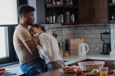 Sabahları modern mutfakta kucaklaşan bir çift.