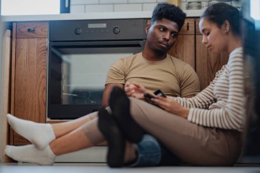 Mutfakta oturmuş akıllı telefonları tartışıyorlar.