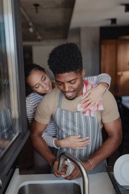 Mutfakta birlikte bulaşık yıkayan çift.
