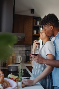Modern mutfakta şarap içen bir çift.