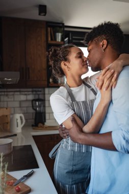 Birlikte yemek pişirirken modern mutfakta kucaklaşan çift.