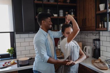 Modern mutfakta eğlenceli dans eden sevimli bir çift.