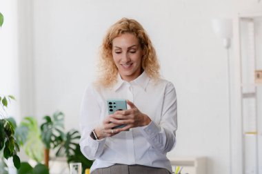 Modern ofiste Smartphone kullanan kadın 