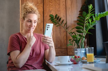 Mutfakta cep telefonu kullanan kadın. 