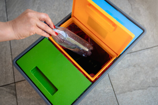 woman hand putting garbage into a trash can, sorting boxes 