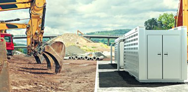 Pil deposu olan modern bir solarfield şantiyesinde inşaat makineleri.