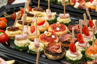 The buffet at the reception. Assortment of canapes. Banquet service. Catering, snacks with different types of cheese and meat. Party Concept.