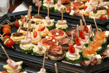 The buffet at the reception. Assortment of canapes. Banquet service. Catering, snacks with different types of cheese and meat. Party Concept.